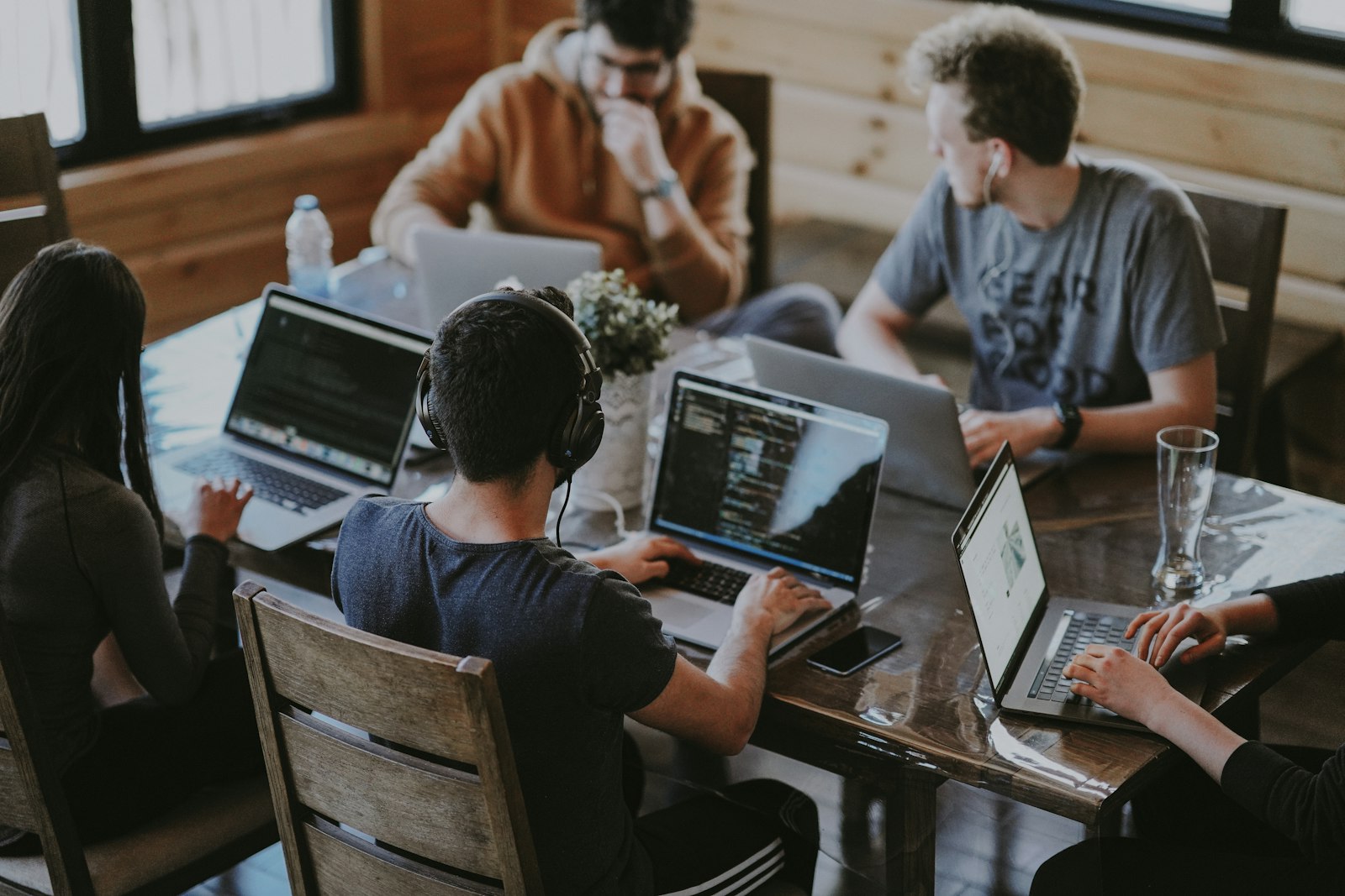 Software engineers gathered around laptops, reviewing work together at a shared table